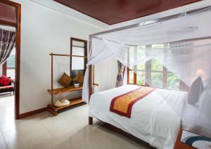 een slaapkamer met een wit bed en een raam bij Phong Nha Lake House Resort in Phong Nha