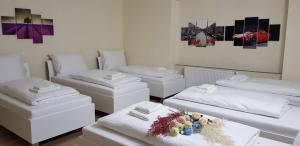 a room with four beds and a table with flowers at Pension TV in Planá