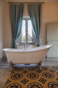 a bath tub in a bathroom with a window at Villa Garibaldi in Bettolle +45 photos