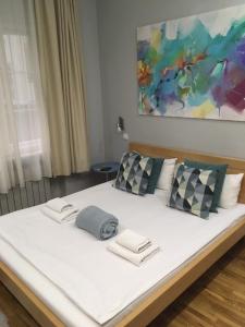 1 cama blanca grande con 2 almohadas y una pintura en L9 Top Central Rooms and Apartments 2, en Belgrado