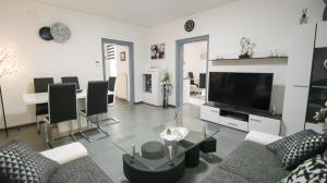a living room with a couch and a tv and a table at Haus Renè in Villach