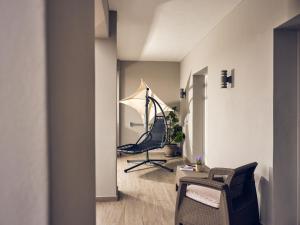 einen Salon mit einem Stuhl und einem Sonnenschirm in einem Zimmer in der Unterkunft Savvas Luxury Suites in Laganas
