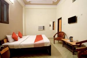 a bedroom with a bed and a desk and a chair at Hotel Sky Inn in Jaipur