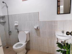 a bathroom with a toilet and a sink at NoBi's Inn, Port Barton in San Vicente