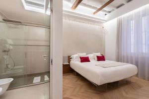 a white bedroom with a bed and a shower at Poēsis Experience Hotel in Rome