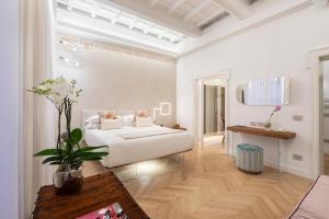 Poēsis Experience Hotel في روما: غرفة بيضاء مع سرير وطاولة