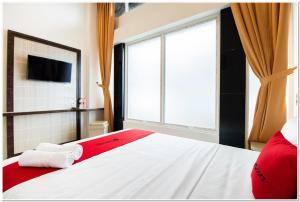 a bedroom with a bed and a large window at RedDoorz Plus @ Centrium Katamso Medan in Medan