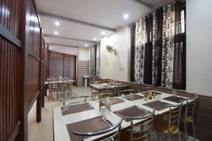 a restaurant with tables and chairs in a room at Hotel Sky Inn in Jaipur