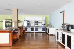 a large kitchen with white appliances and wooden floors at Blue Sea Lanzarote Palm in Puerto del Carmen