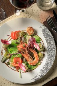 a plate of food with shrimp and vegetables on a table at 7Hotel&Spa in Illkirch-Graffenstaden