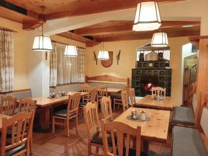 a dining room with tables and chairs and a fireplace at Hotel Gailberghöhe in Kötschach