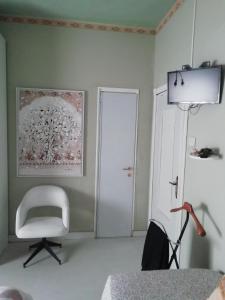 Cette chambre comprend une chaise blanche et une porte blanche. dans l'établissement B&B Art, à Bussolengo