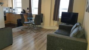 sala de estar con sofá y mesa con sillas en Atlantic Mansions 2 Bedroom Split Level Apartment en Southampton
