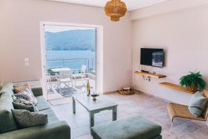 Kalavria Luxury Suites - magnificent sea view of Poros في بوروس: غرفة معيشة مع أريكة وطاولة
