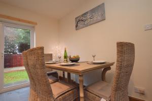 jadalnia z drewnianym stołem i krzesłami w obiekcie Bay Cottage w mieście Dunoon