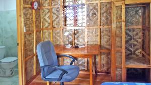 Zimmer mit einem Schreibtisch, einem Stuhl und einem Fenster in der Unterkunft MJ Room Rental Mahogany in Dauis