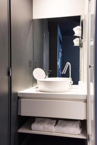 a bathroom with a white sink and a mirror at Hôtel Ar Iniz in Saint Malo