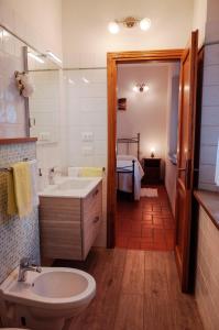 W łazience znajduje się umywalka, toaleta i lustro. w obiekcie Poggio Al Vento w mieście Castiglione dʼOrcia
