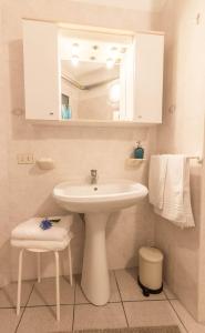 Un baño blanco con lavabo y espejo. en Al Pipái, en Ferrara 20 fotos más