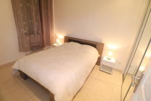 ein Schlafzimmer mit einem weißen Bett und zwei Nachttischen in der Unterkunft Carré d'Or 1 bedroom 2 mins from Croisette 5 from Palais 243 in Cannes