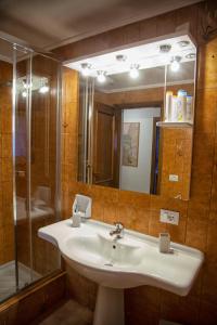 La salle de bains est pourvue d'un lavabo, d'une douche et d'un miroir. dans l'établissement Ca' Bianca Relax Apartment, sur le Lido de Venise