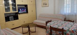 Zimmer mit einem Bett, einem Stuhl und einem TV in der Unterkunft Appartamenti Clara in Poreč