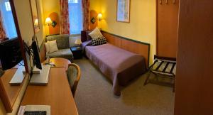 - une chambre avec un lit, une chaise et un bureau dans l'établissement Amadeus Boutique Hotel Deutscher Hof, à Georgenthal