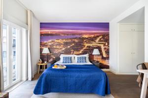 - une chambre avec un lit bleu et une vue sur la ville dans l'établissement ALTIDO Chic studio in Principe Real, nearby Botanical Garden of Lisbon, à Lisbonne