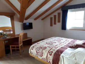 a bedroom with a bed and a desk and a television at Hotel Panorama in Passo del Tonale