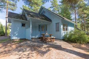 ein blaues Haus mit einem Picknicktisch davor in der Unterkunft Yyteri Holiday Cottages in Pori