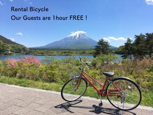 ein rotes Fahrrad, das auf einem Bürgersteig neben einem Berg geparkt ist in der Unterkunft Shoji Mount Hotel in Fujikawaguchiko