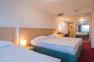 a hotel room with two beds and two lamps at Riga Islande Hotel with FREE Parking in Riga