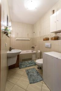a bathroom with a sink and a tub and a toilet at Ann Apartament Horyzont in Gdańsk