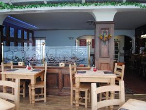 um restaurante com mesas e cadeiras e um balcão em Trecastell Hotel em Amlwch