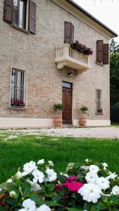 a house with a balcony and flowers in front of it at Villa Blanco's in Morciano di Romagna