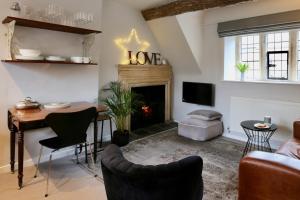 a living room with a table and a fireplace at Cotswolds Place - Chancewell in Broadway