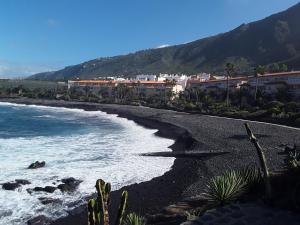a black beach with buildings and the ocean at Ático Andrea in Los Silos