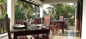 comedor con mesa y sillas en el porche en Nil Menik Villa en Bentota