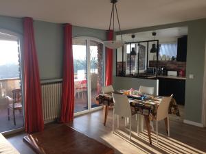 ein Esszimmer mit einem Tisch und roten Vorhängen in der Unterkunft Appartement avec terrasse pour 4 personnes in Athis-Mons