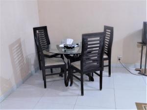 una mesa de comedor negra con 2 sillas negras en High Trees Inn, en Islamabad