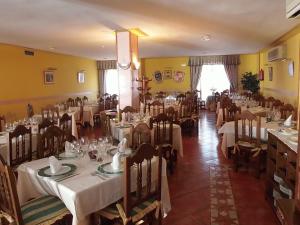 ein Esszimmer mit Tischen und Stühlen sowie weißen Tischdecken in der Unterkunft Hostal-Restaurante San Antolín in Tordesillas