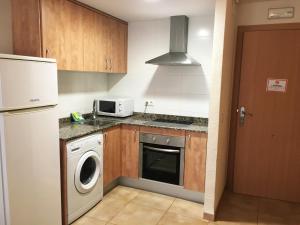 y cocina con lavadora, fogones y microondas. en Apartamentos Doña Carmen 3000, en Oropesa del Mar