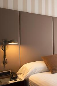 a bedroom with a bed and a desk with a lamp at Zenit Valencia in Valencia
