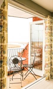 a patio with two chairs and a table on a balcony at Seagull's Sanctuary in Wells next the Sea