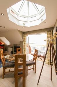 a dining room with a table and a large skylight at Seagull's Sanctuary in Wells next the Sea