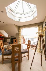 a dining room with a table and a large skylight at Seagull's Sanctuary in Wells next the Sea +7 photos