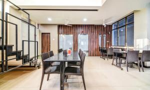 a dining room with black tables and chairs at Treebo Trend Shree Sai Suites in Kolhapur