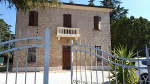 ceglany budynek z bramą i balkonem w obiekcie Villa Blanco's w mieście Morciano di Romagna