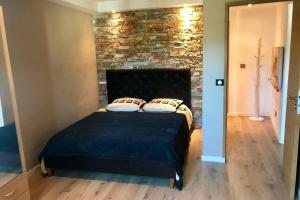 a bed in a room with a brick wall at Villa Solsticia in Porticcio