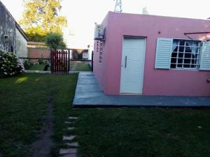 una casa rosa con una puerta blanca y un patio en MONOAMBIENTE para 2 personas, no incluye blanqueria en Chascomús